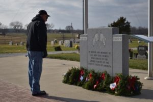 Volunteer inspecting monument at the Wreaths Across America Ceremony